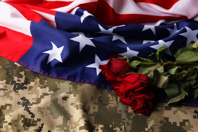 Photo of Veterans day. American flag, roses and military uniform, top view