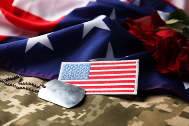 Photo of Veterans day. USA army patch, token, American flag, roses and military uniform, closeup