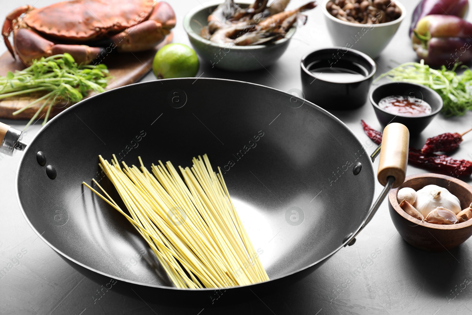 Photo of Different ingredients for wok on light grey table