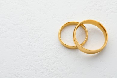 Beautiful golden wedding ring on white table, space for text