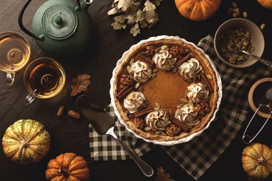 Photo of Flat lay composition with homemade pumpkin pie on black table