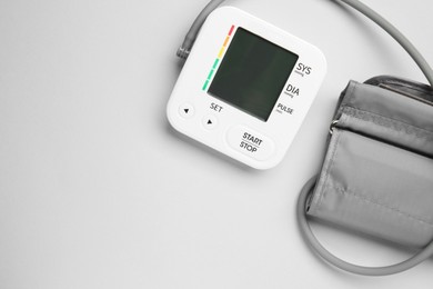 Photo of Blood pressure measuring device on light grey background, top view. Space for text