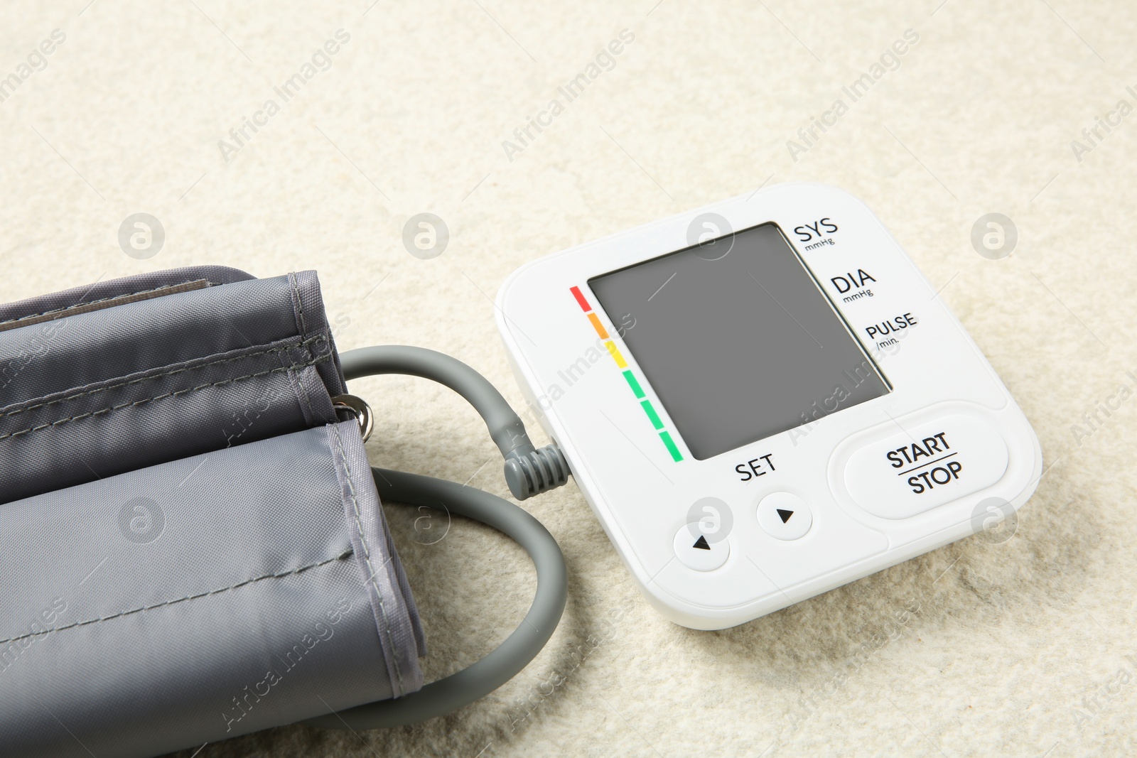 Photo of Blood pressure measuring device on light textured background, closeup