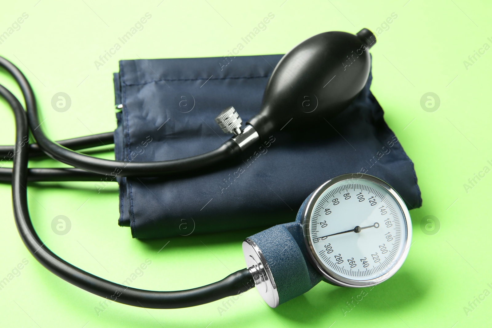 Photo of Blood pressure measuring device on green background, closeup