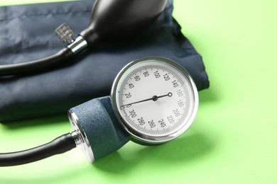 Photo of Blood pressure measuring device on green background, closeup