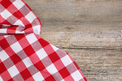 Photo of Crumpled tablecloth with checkered pattern on wooden table, top view. Space for text