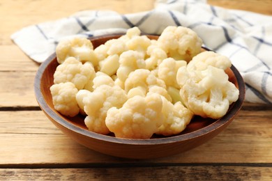 Photo of Tasty cauliflower in bowl on wooden table, closeup