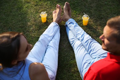 Couple spending time together on green lawn in park, selective focus