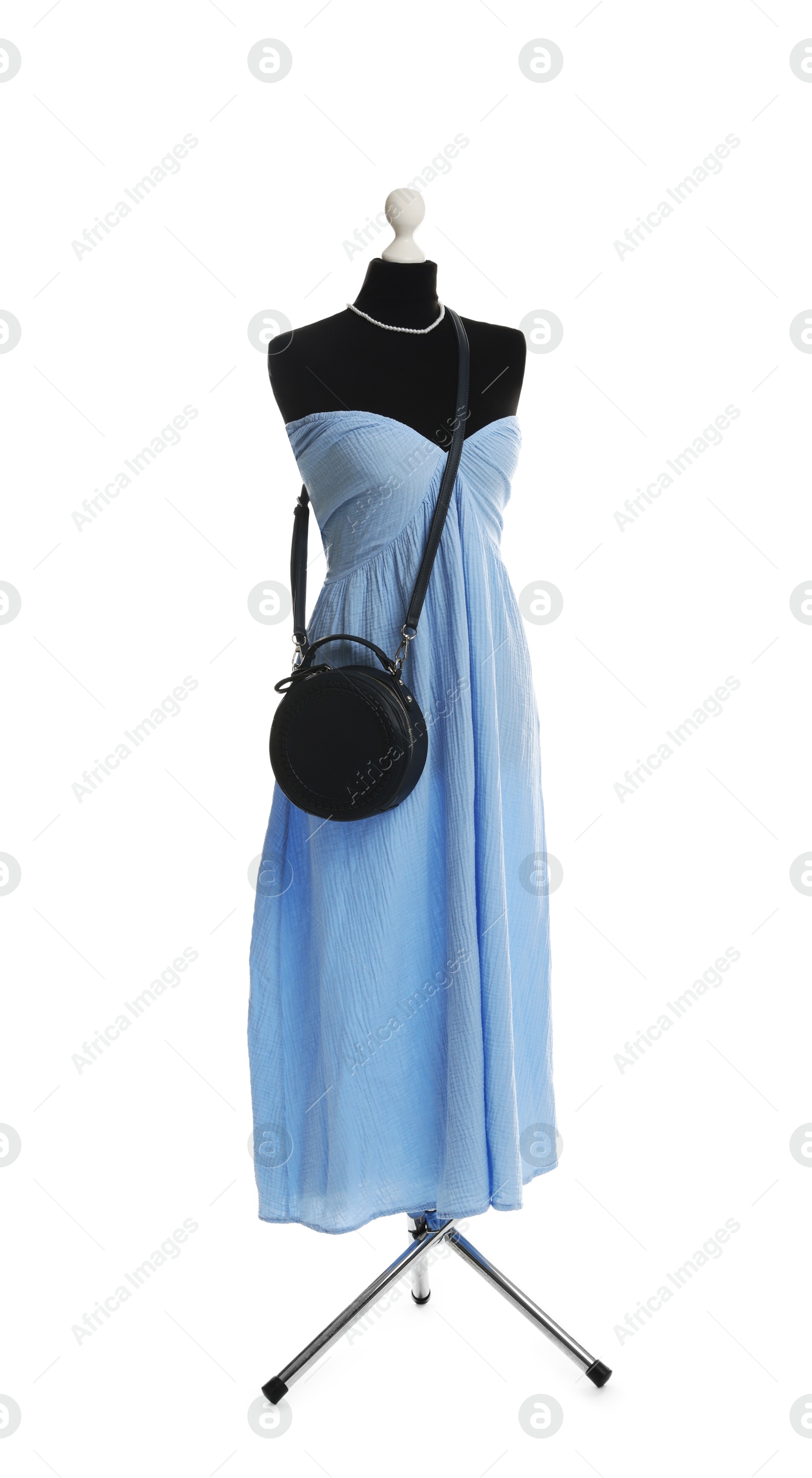 Photo of Female mannequin with light blue dress and black bag isolated on white