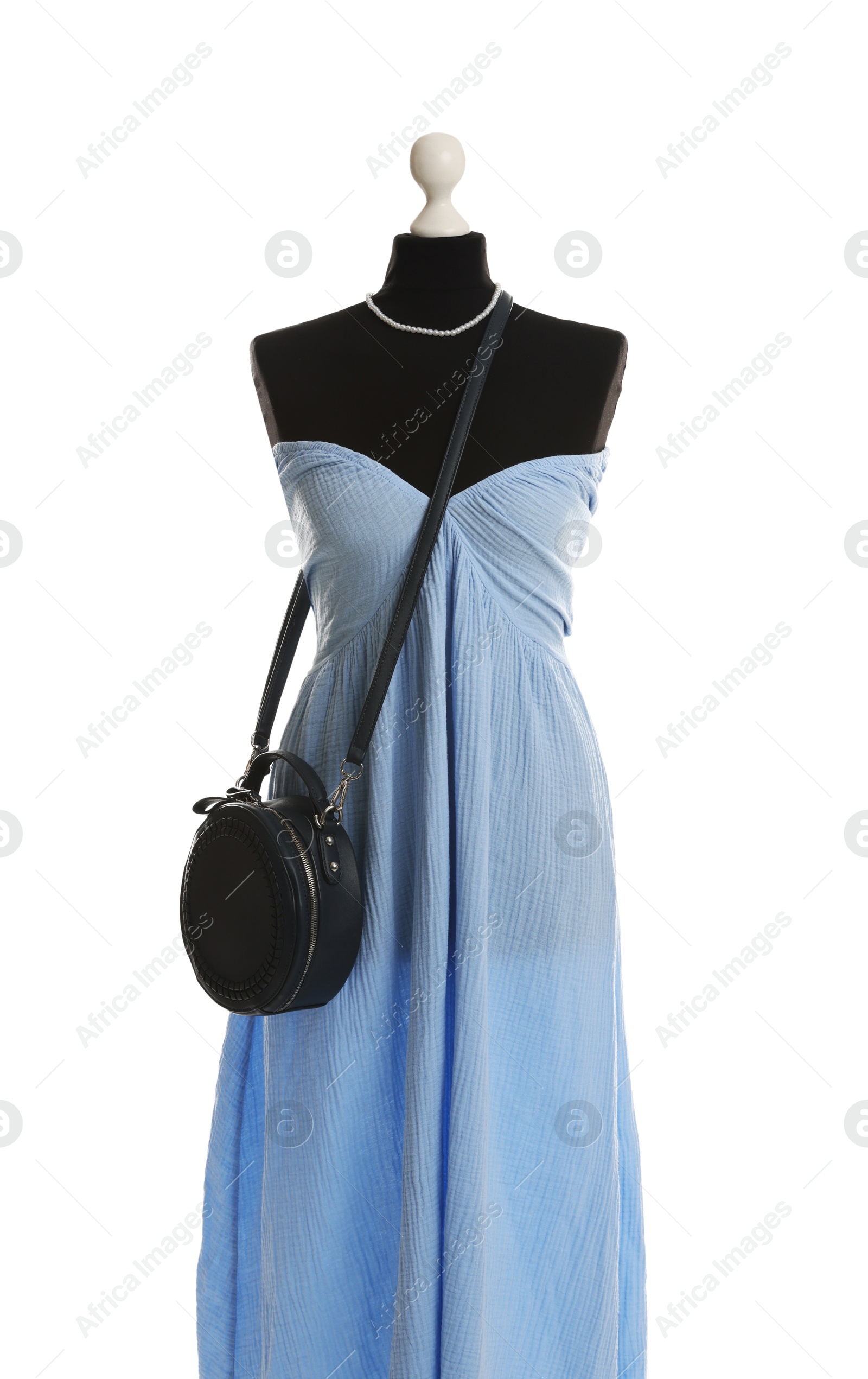 Photo of Female mannequin with light blue dress and black bag isolated on white