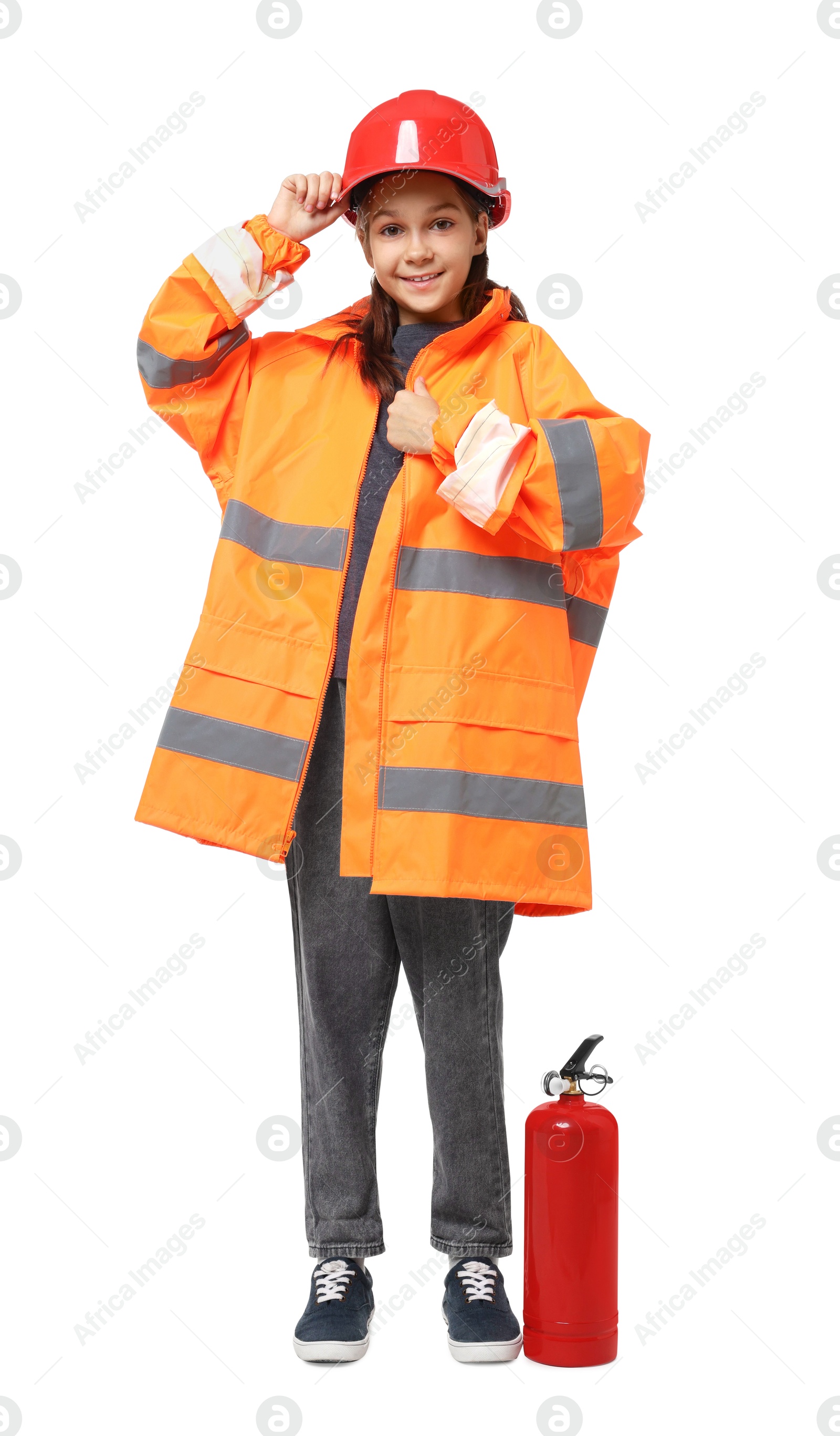 Photo of Girl with hardhat, fire extinguisher and vest pretending to be firefighter on white background. Dreaming of future profession