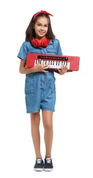 Girl with headphones and electric piano pretending to be musician on white background. Dreaming of future profession