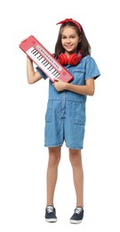 Girl with headphones and electric piano pretending to be musician on white background. Dreaming of future profession