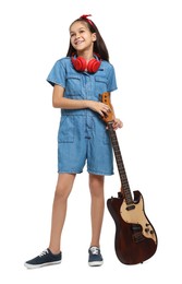 Photo of Girl with headphones and guitar pretending to be musician on white background. Dreaming of future profession