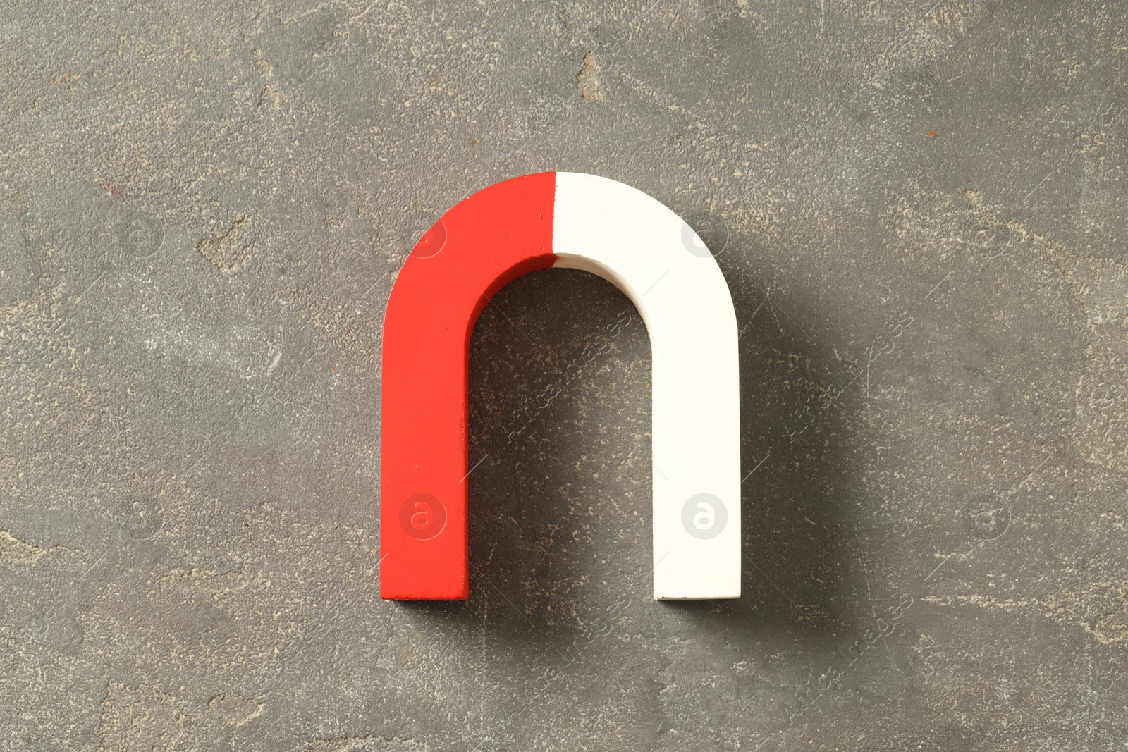 Photo of One horseshoe magnet on grey textured background, top view