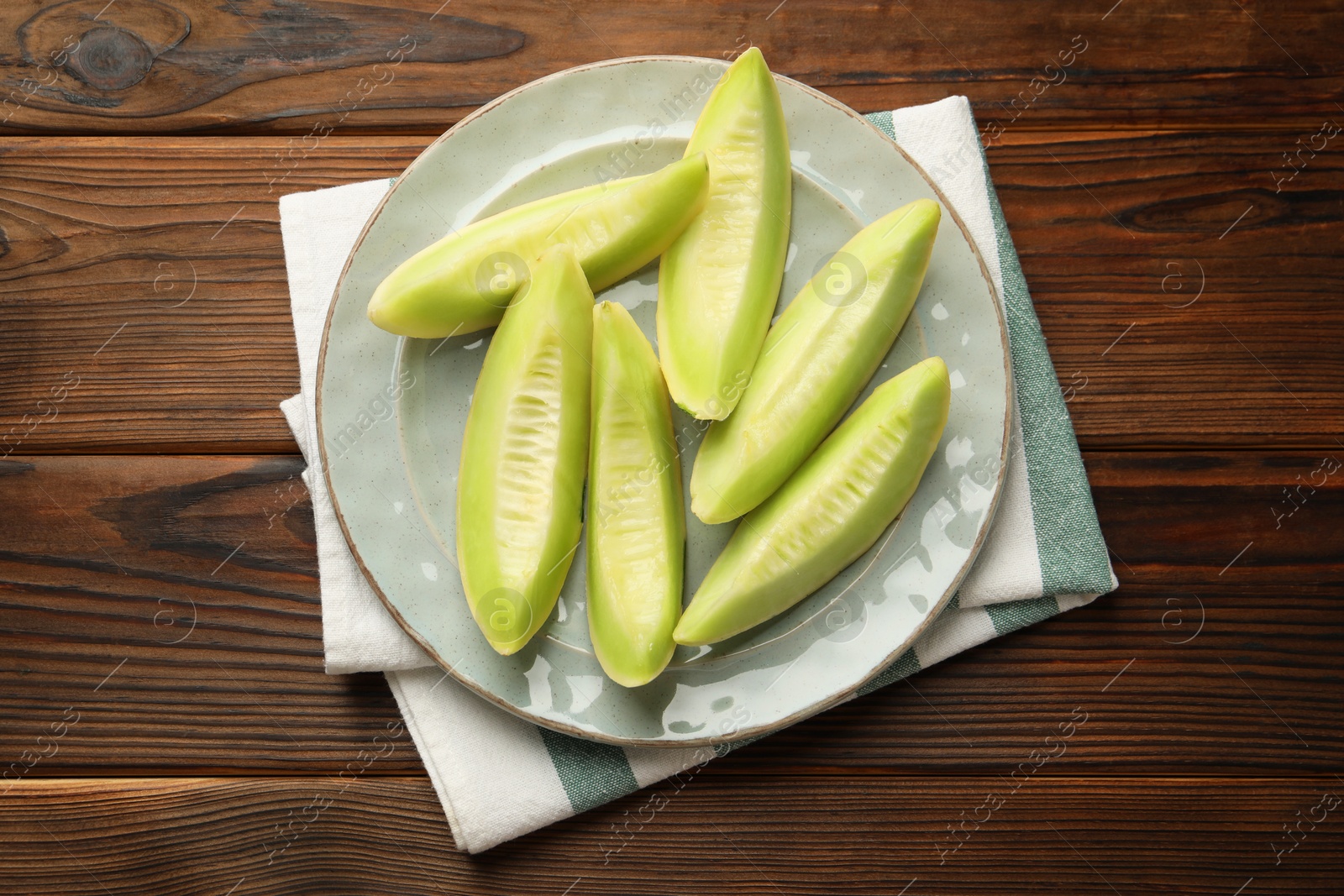 Photo of Fresh cut honeydew melon on wooden table, top view