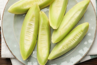 Photo of Fresh cut honeydew melon on wooden table, top view