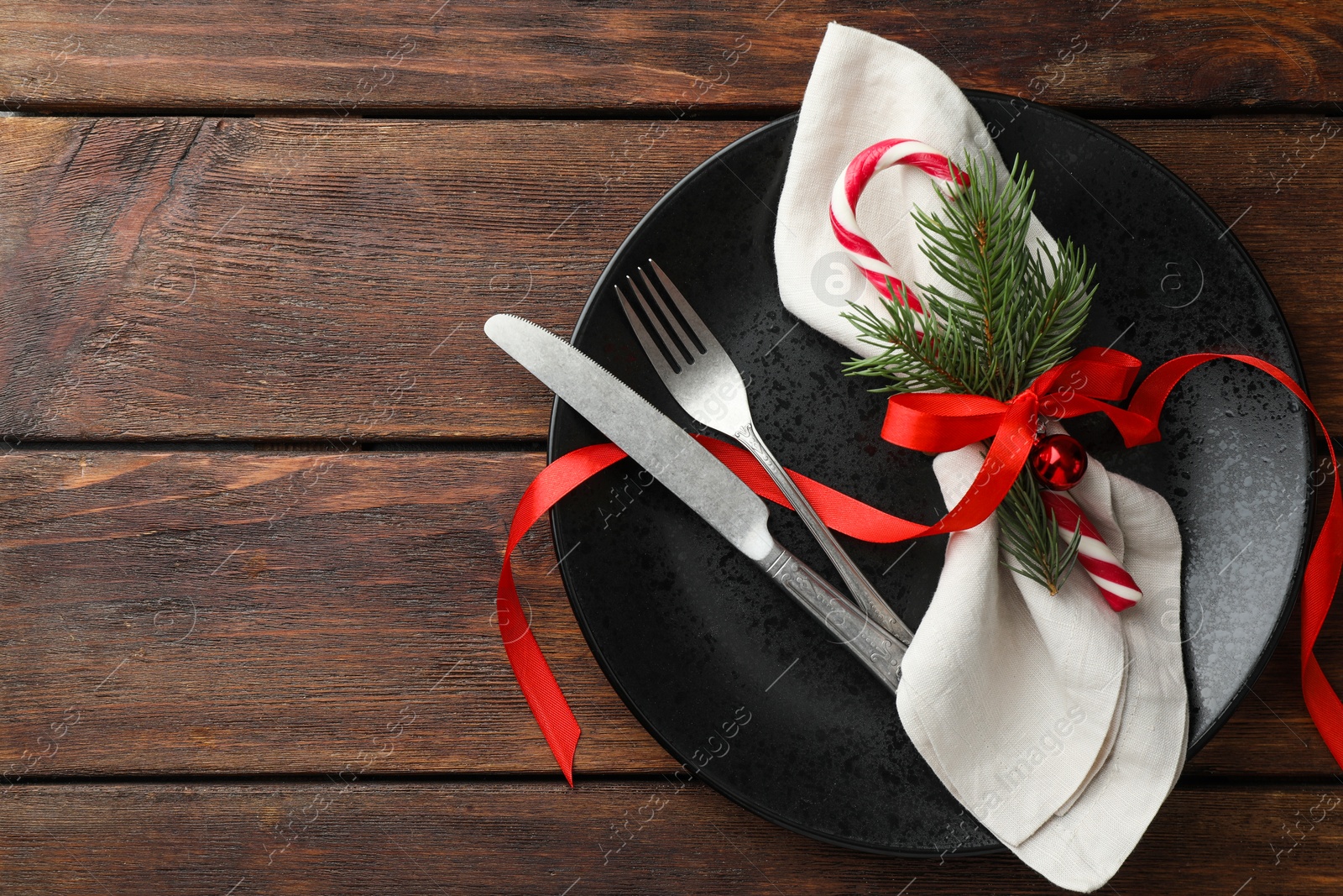 Photo of Christmas setting with festive decor on wooden table, top view. Space for text