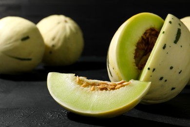 Photo of Fresh ripe honeydew melon on dark table, closeup