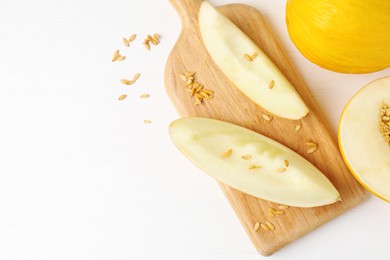 Fresh ripe melons on white wooden table, flat lay. Space for text