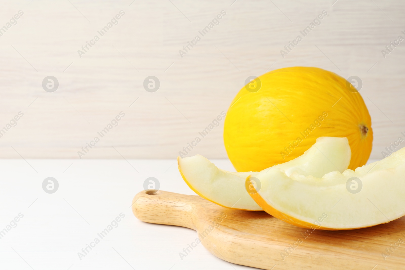 Photo of Fresh ripe melons on white table. Space for text