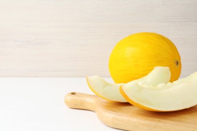 Photo of Fresh ripe melons on white table. Space for text