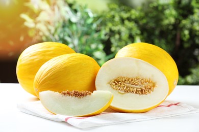 Photo of Fresh ripe melons on white table outdoors