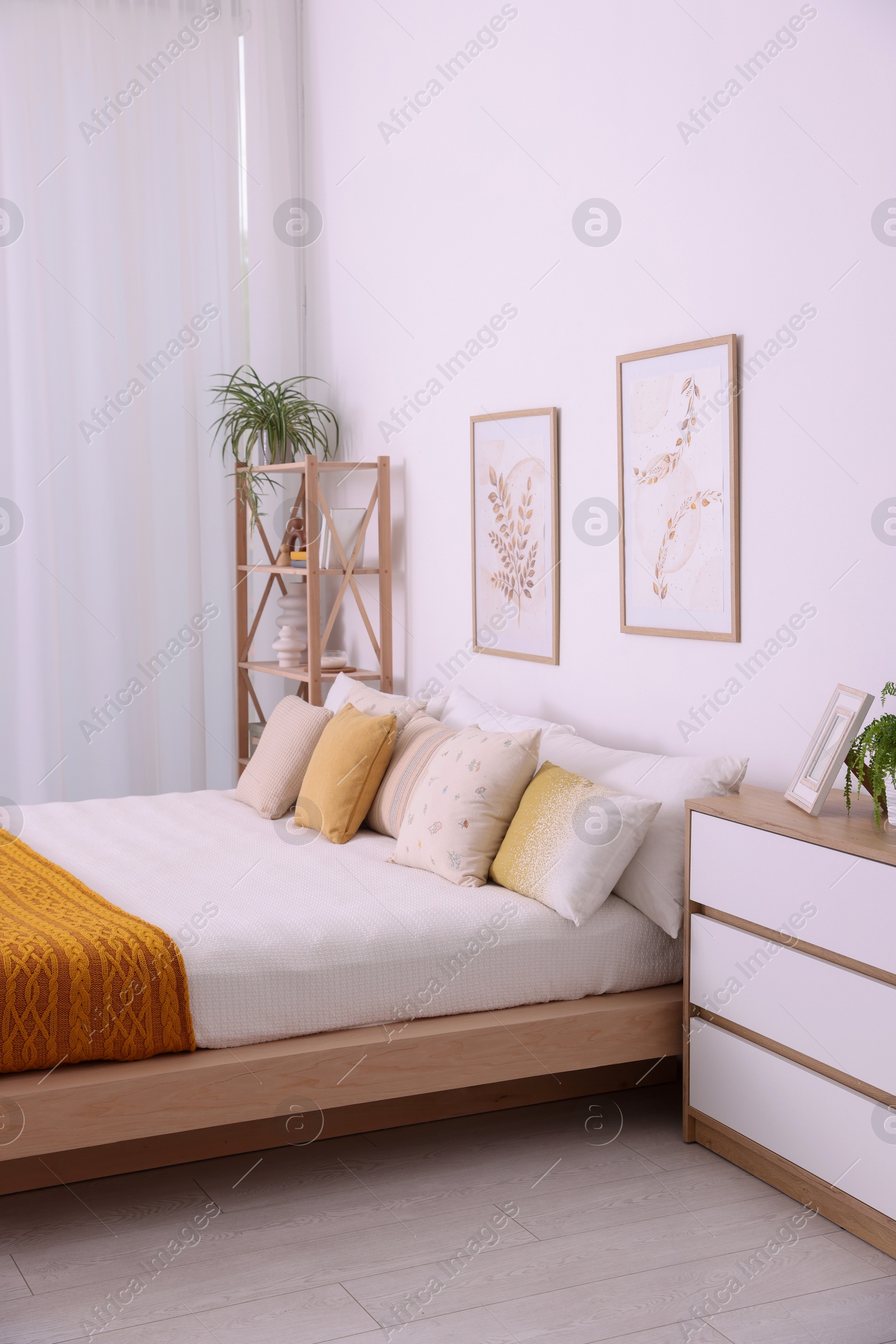 Photo of Large bed near white wall in room. Stylish bedroom interior