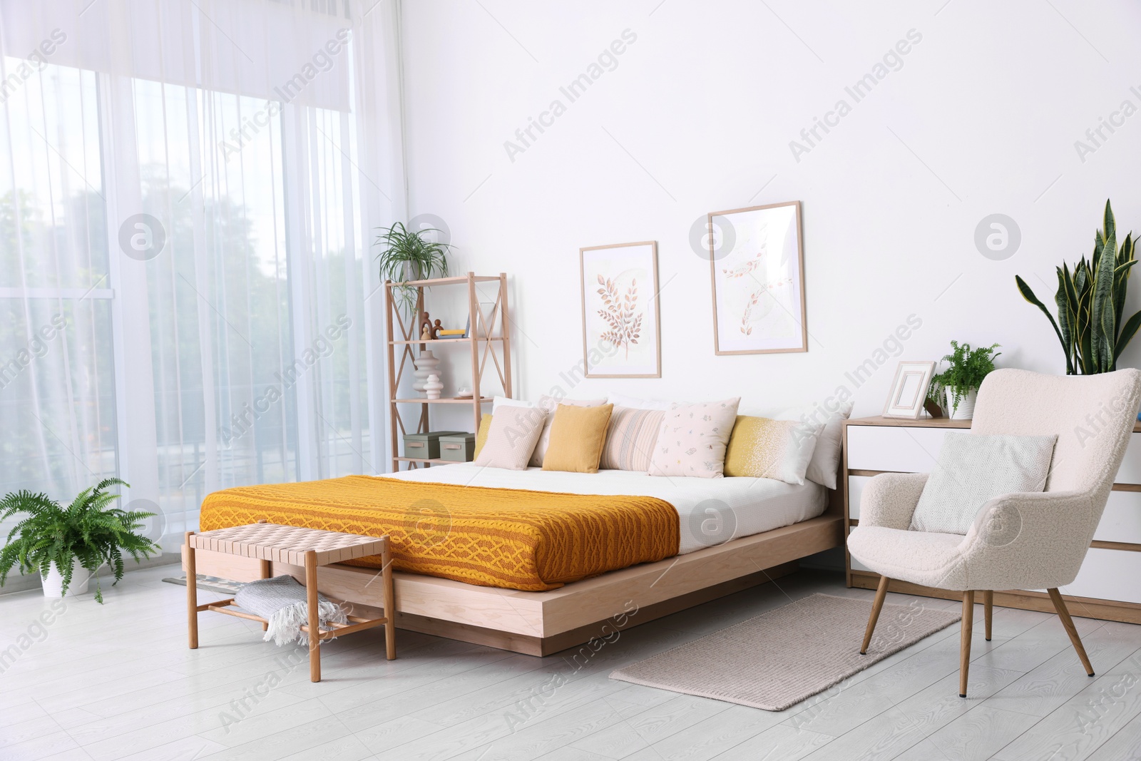 Photo of Large bed near window in room. Stylish bedroom interior