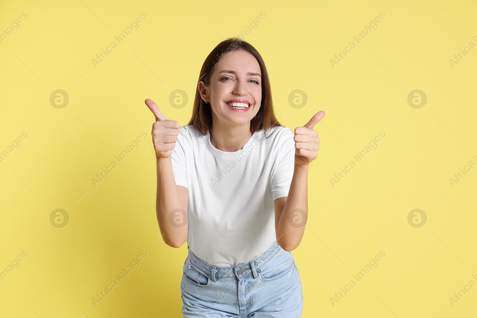 Photo of Happy winner showing thumbs up on yellow background