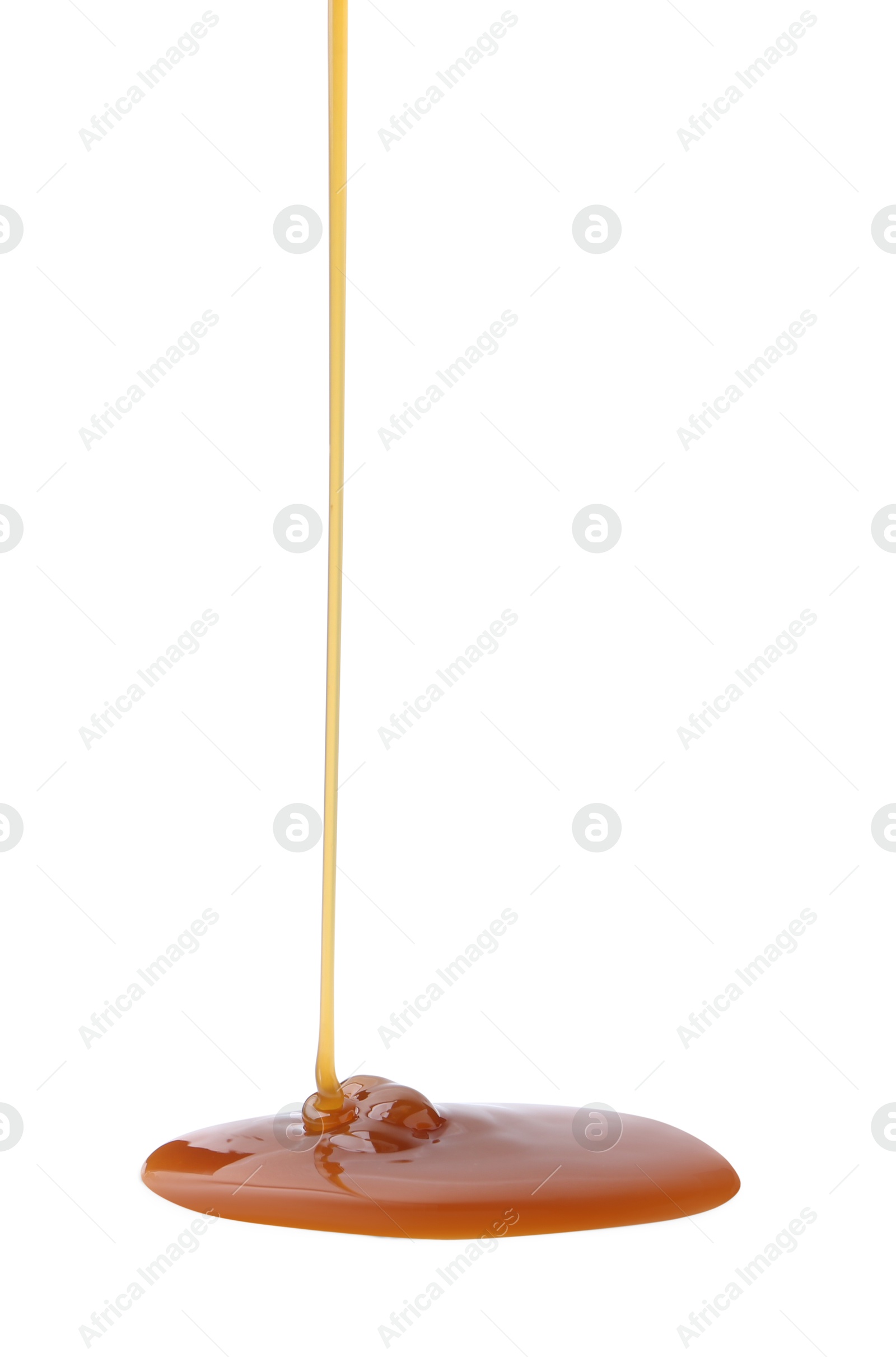 Photo of Tasty caramel sauce dripping on white background, closeup