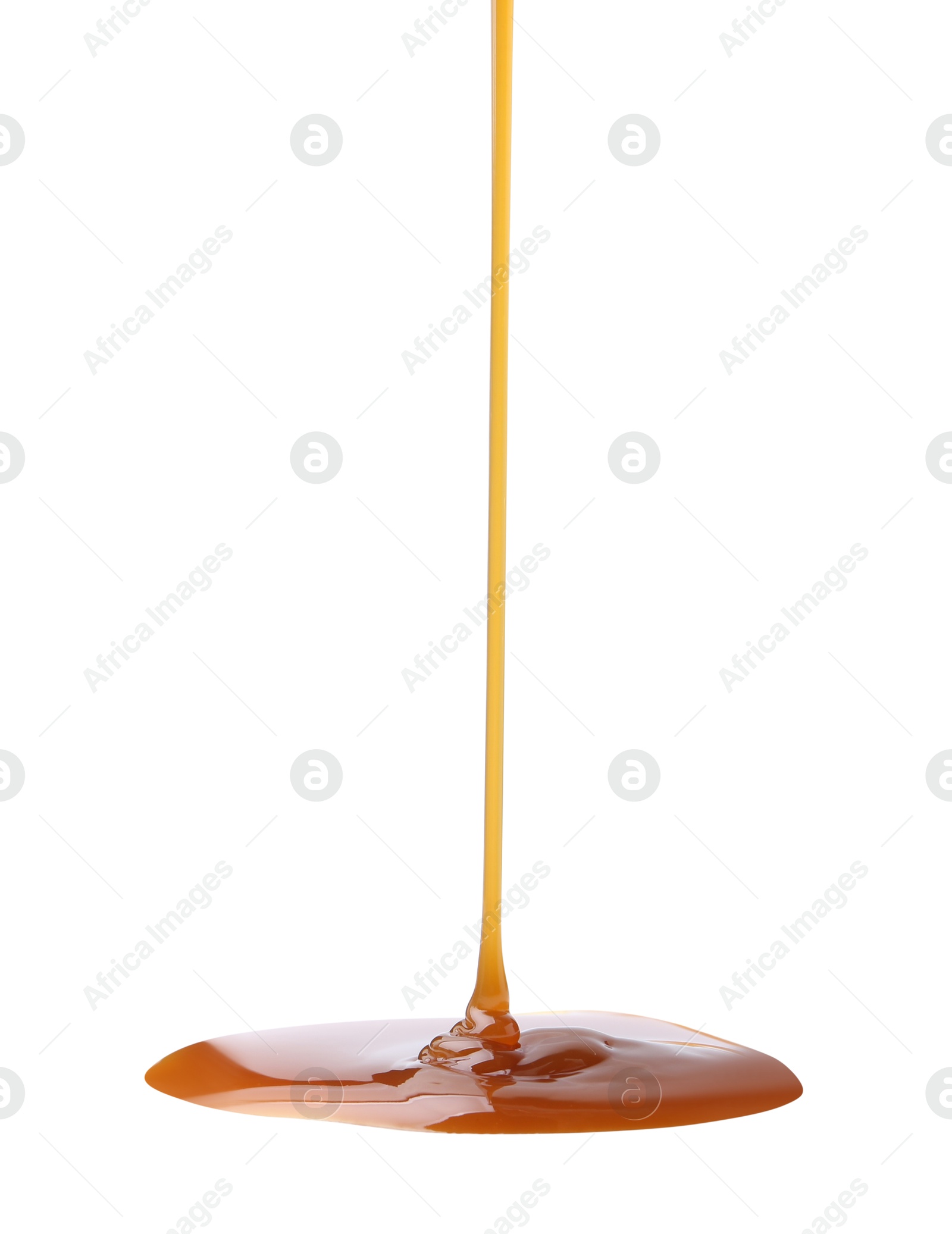 Photo of Tasty caramel sauce dripping on white background, closeup