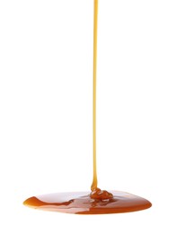 Photo of Tasty caramel sauce dripping on white background, closeup