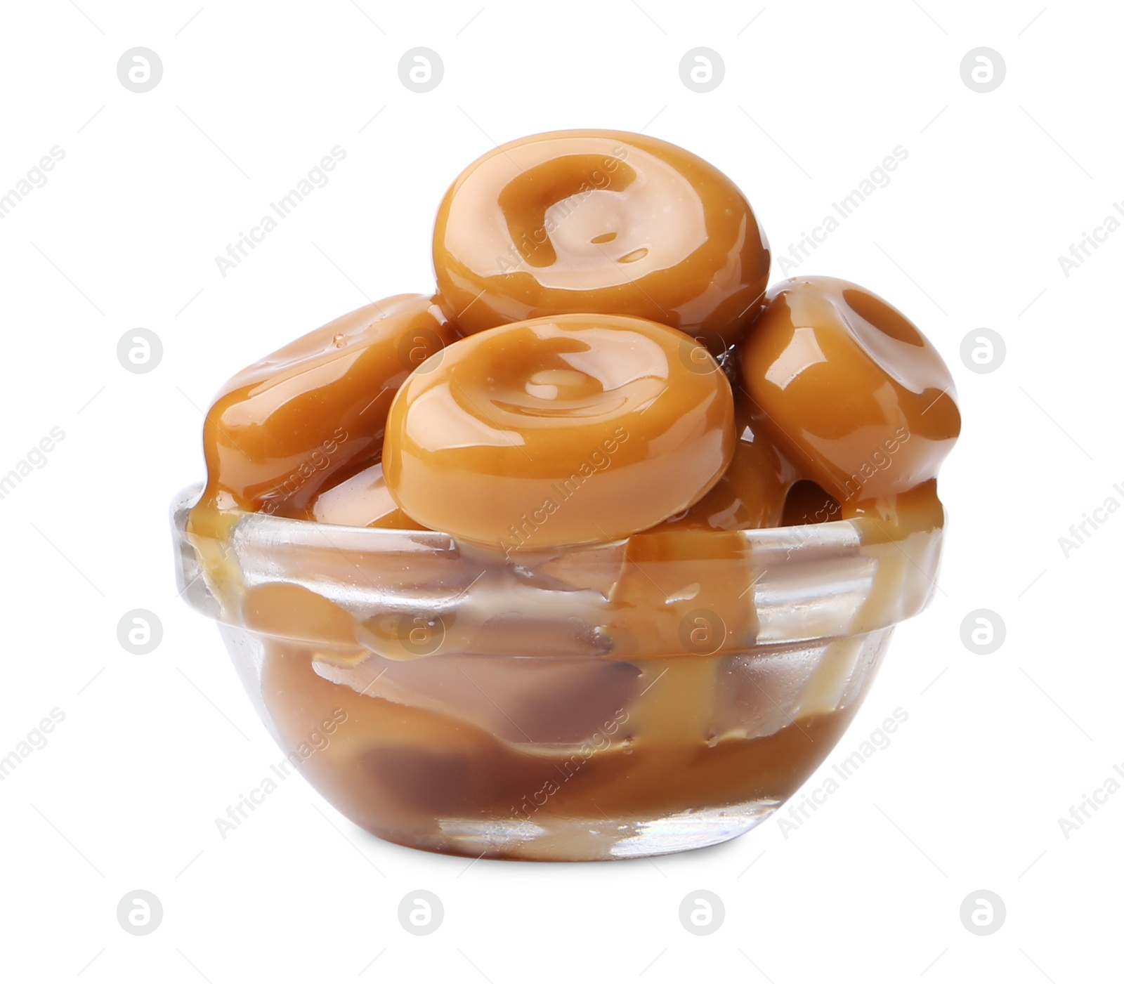 Photo of Tasty candies with caramel sauce in glass bowl isolated on white