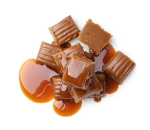 Photo of Tasty candies with caramel sauce isolated on white, top view