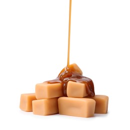 Photo of Caramel sauce dripping onto candies on white background, closeup