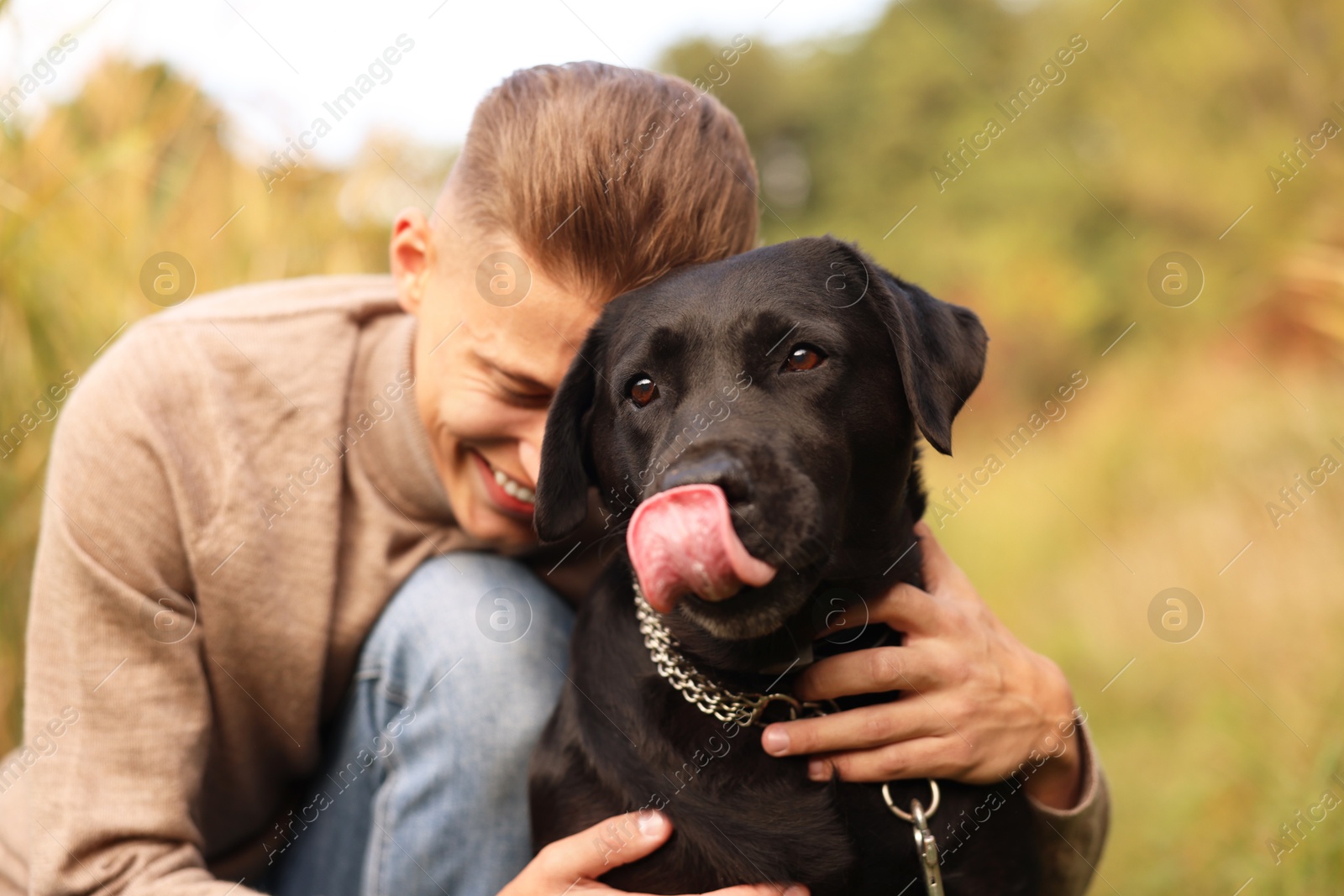 Photo of Smiling man with cute dog outdoors on autumn day