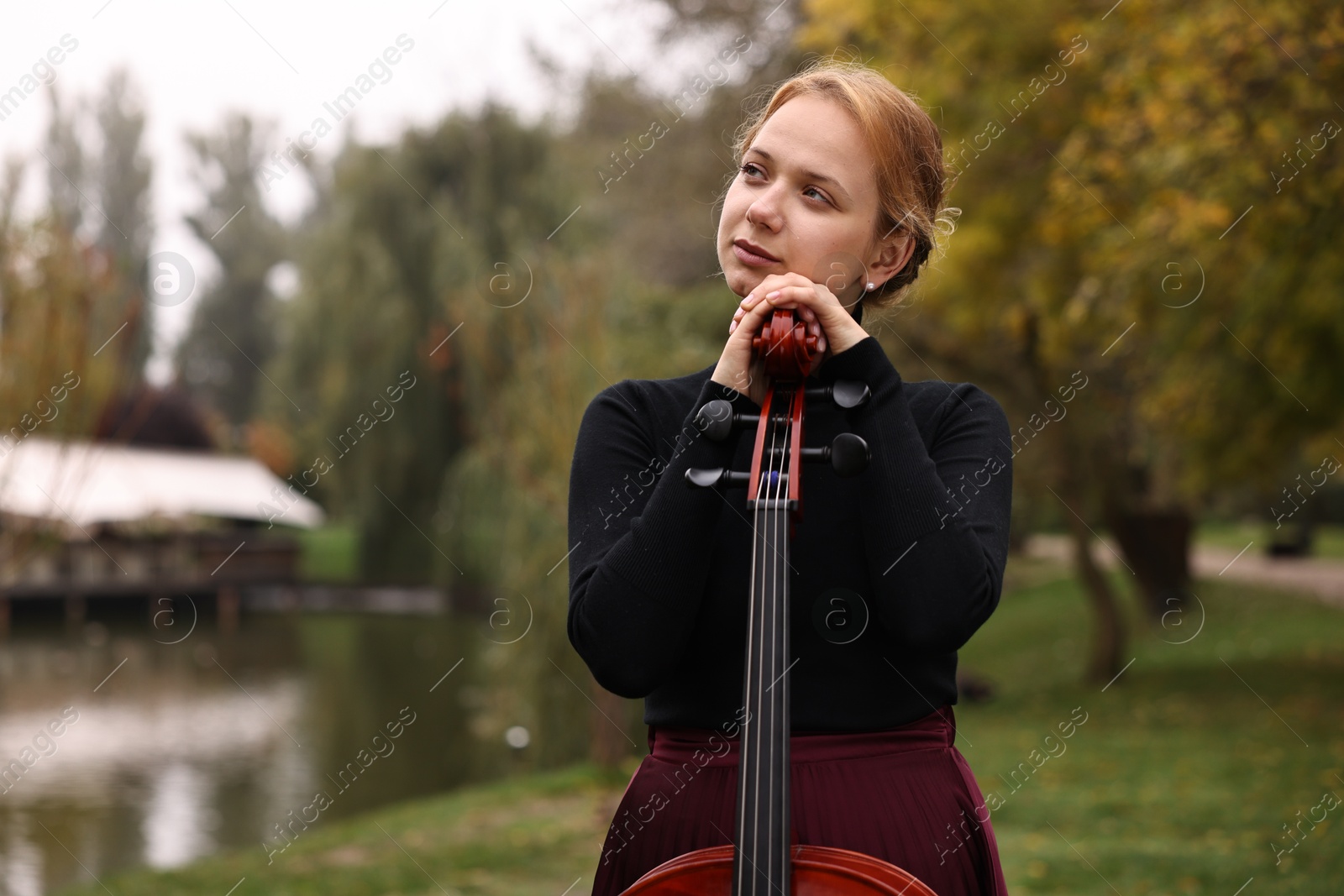 Photo of Beautiful young woman with cello in park