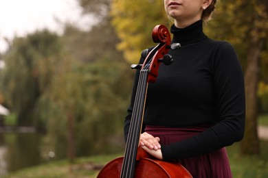 Photo of Young woman with cello in park, closeup. Space for text