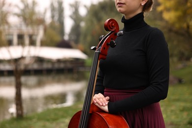 Photo of Young woman with cello in park, closeup. Space for text