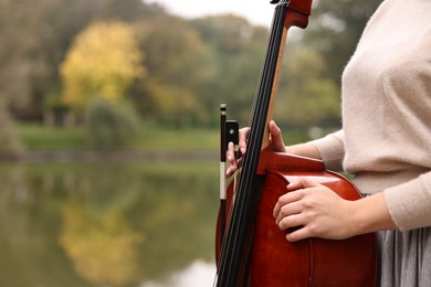 Photo of Young woman with cello in park, closeup. Space for text