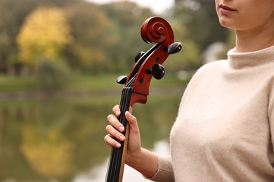 Photo of Young woman with cello in park, closeup. Space for text