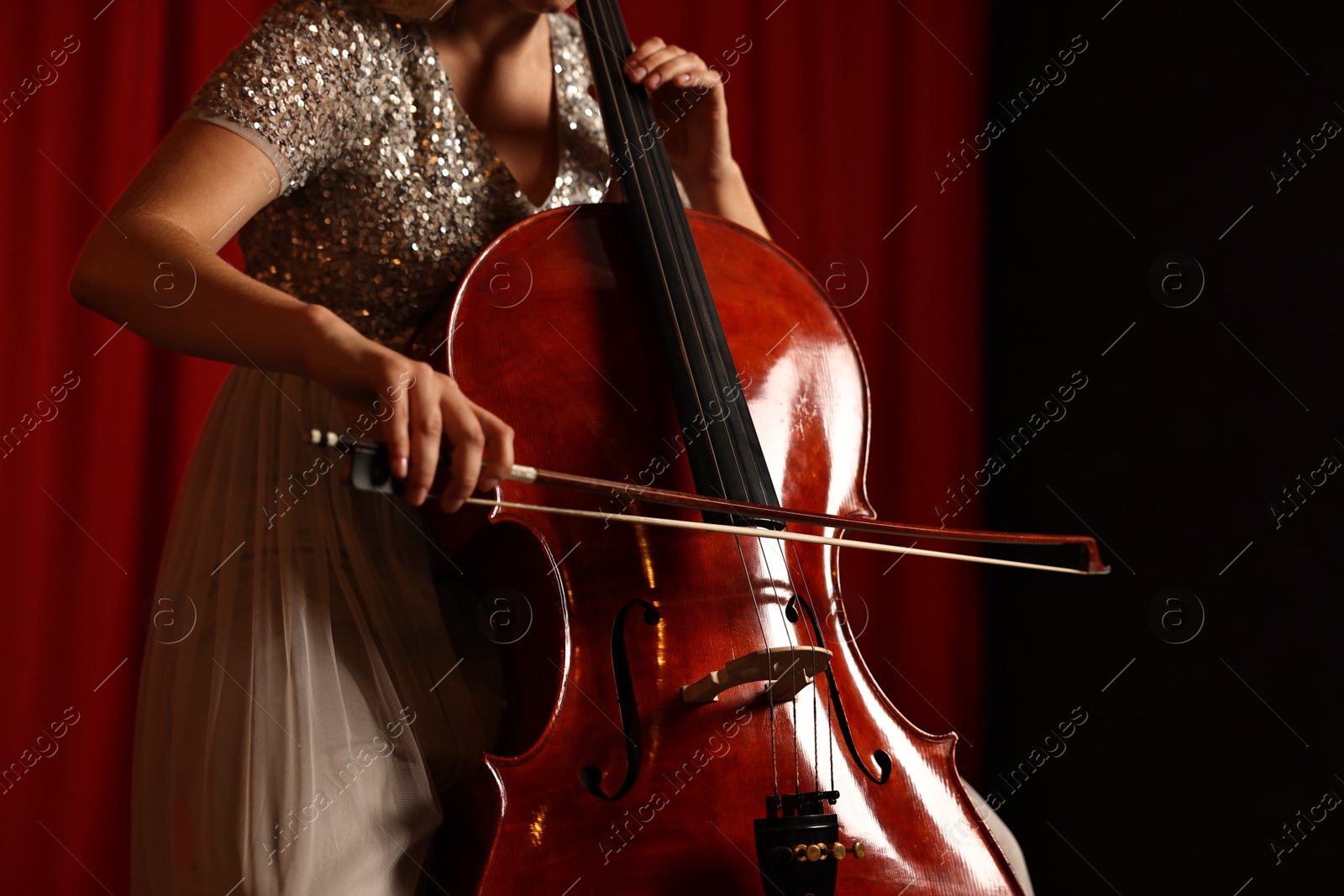 Photo of Young woman playing cello on stage, closeup