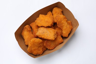 Photo of Delicious chicken nuggets in carton box on white background, top view