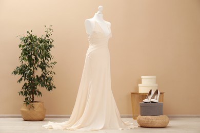 Photo of Beautiful wedding dress on mannequin and shoes in boutique