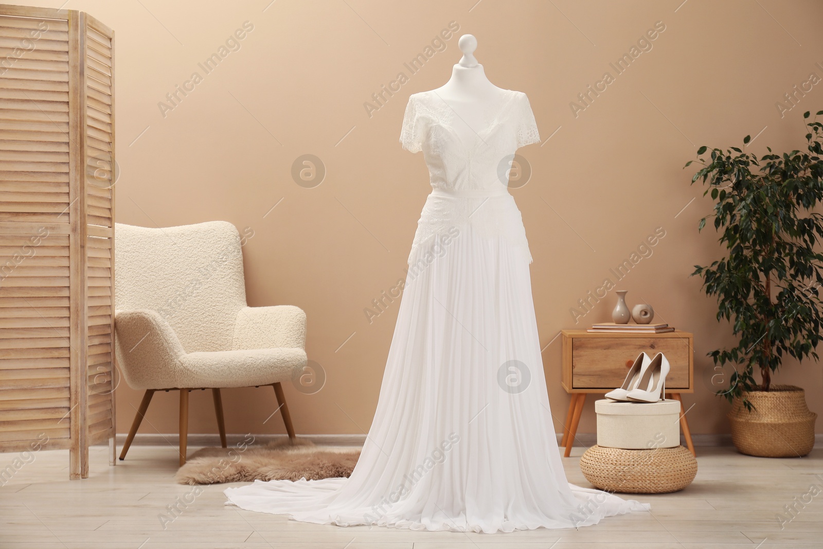 Photo of Beautiful wedding dress on mannequin and shoes in boutique