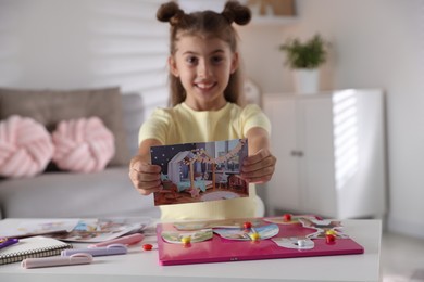 Photo of Creating vision board. Girl with picture at light table indoors, selective focus