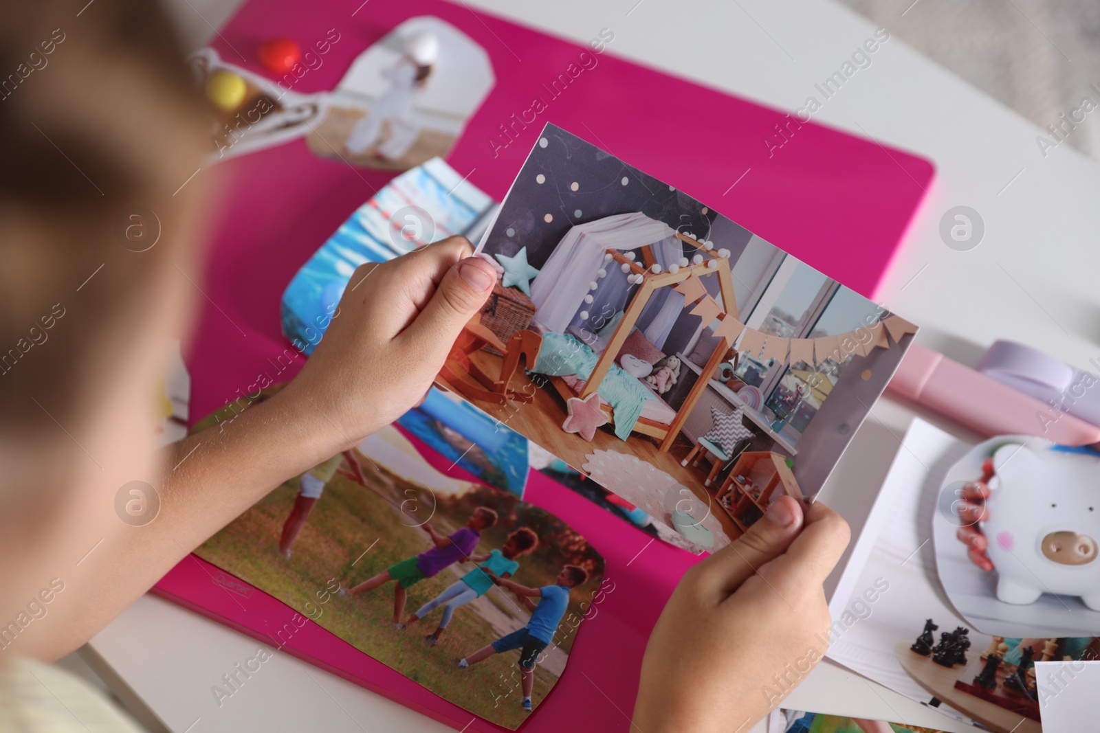 Photo of Girl creating vision board with different pictures at light table, selective focus