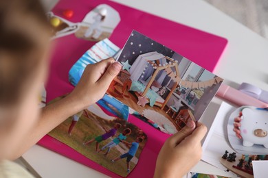 Girl creating vision board with different pictures at light table, selective focus