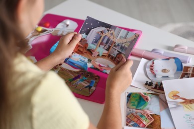 Creating vision board with different pictures at light table, closeup